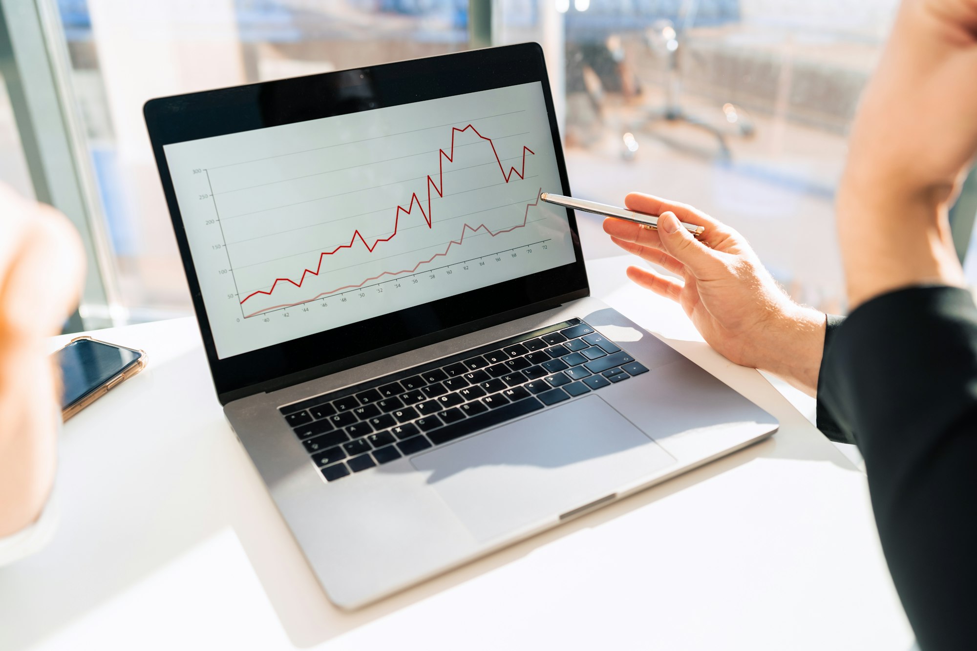 Office workers watching company growth chart on laptop