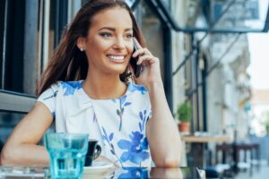 Young woman at sidewalk cafe talking on the mobile phone