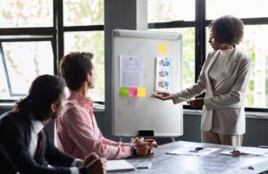 Black woman business coach speaker in suit giving presentation